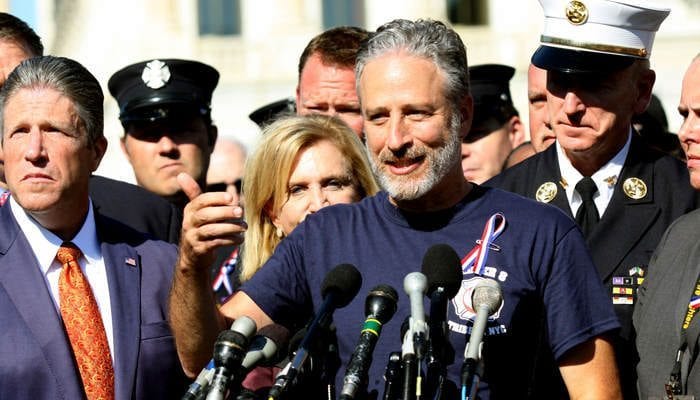 Comedian Jon Stewart stands with New York City first responders during a rally on Capitol Hill in Washington, Wednesday, September 16, 2015, calling for the extension of the the Zadroga Heath & Compensation Act that provides health care and compensation to 9/11 first responders and victims will come to an end if not renewed by Congress. (AP Photo/Lauren Victoria Burke)