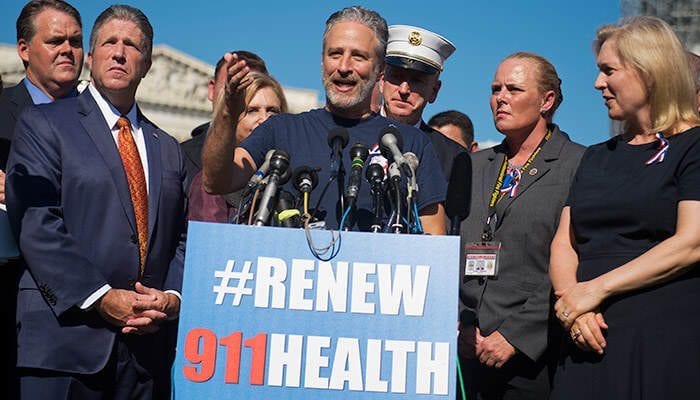 UNITED STATES - SEPTEMBER 16: Jon Stewart attends a rally on the East Front of the Capitol with members of the FDNY to urge Congress to extend healthcare benefits for first responders who suffer from cancer and other ailments as a result of their work at ground zero after the 9/11 attacks, September 16, 2015. Sen. Kirsten Gillibrand, D-N.Y., appears at right. (Photo By Tom Williams/CQ Roll Call) (CQ Roll Call via AP Images)
