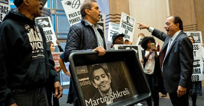 FILE - In this Thursday, Oct. 1, 2015, file photo, carrying an image of Turing Pharmaceuticals CEO Martin Shkreli in a makeshift cat litter pan, AIDS activists and others are asked to leave the lobby during a protest highlighting pharmaceutical drug pricing. Shkreli, the former hedge fund manager under fire for buying a pharmaceutical company and ratcheting up the price of a life-saving drug, is in custody following a securities probe, Thursday, Dec. 17, 2015. (AP Photo/Craig Ruttle, File)