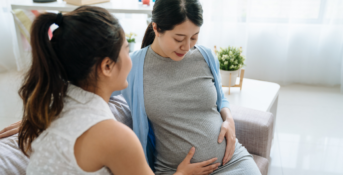 pregnant woman in doctor's office holding belly