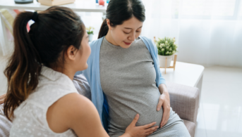 pregnant woman in doctor's office holding belly