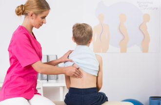 young child getting a spinal adjustment from medical professional