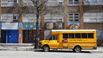 school bus parked in front of a city building
