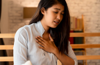 woman clutching chest, trying to catch breath from asthma attack