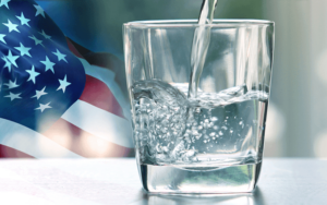 A glass of water with an American flag in the background