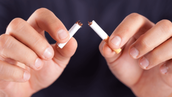 close up of hands breaking a cigarette in half
