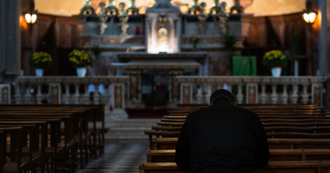 A man kneeling in a church