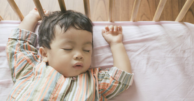 baby sleeping flat on back in crib