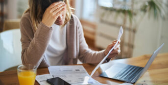 Woman sits over insurance documents