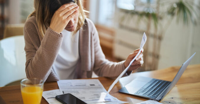 Woman sits over insurance documents