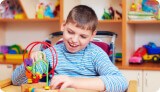 Child with cerebral palsy playing with toys