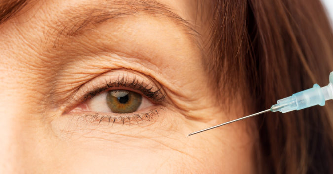 close up of womans eye with syringe