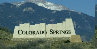 colorado springs sign in front of mountain landscape