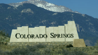 colorado springs sign in front of mountain landscape
