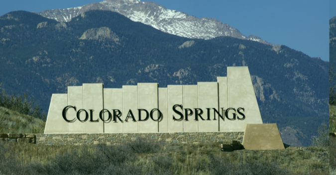 colorado springs sign in front of mountain landscape