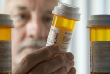 Man looking at prescription medicine bottles