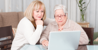 two elderly women looking at a laptop computer