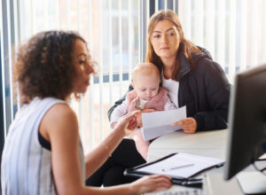 An attorney meets with a woman who is holding a baby