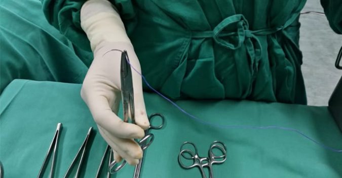 a medical professional handles surgical tools in an operating room