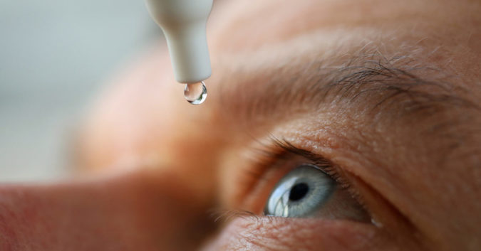 Person putting eye drops in eyes