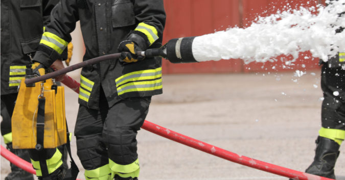 firefighter using a fire hose
