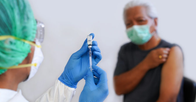 an older person about to get a flu shot