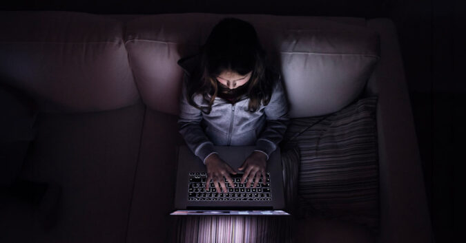 A young child using a laptop at night