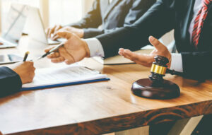 Lawyers gesture with their hands as they sit across from each other