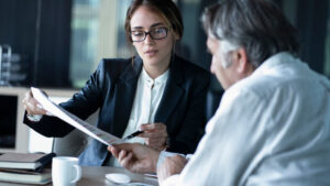 Lawyer holding up a document and speaking with client