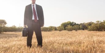 A lawyer stands in a field