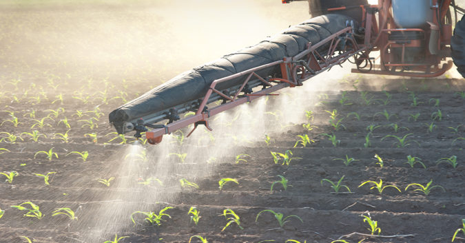 machine spraying weed killer on crops