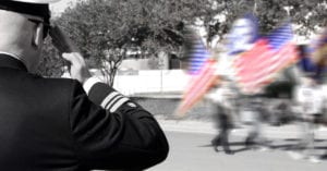 Veteran salutes parade of American flags