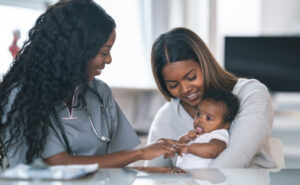 A female nurse caring for a mother and her baby