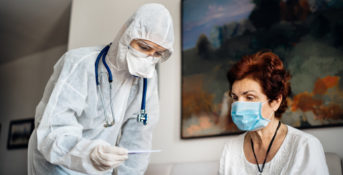 nursing home resident getting temperature taken by nurse