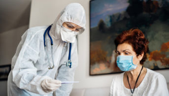 nursing home resident getting temperature taken by nurse