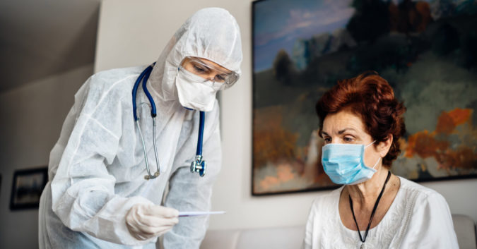 nursing home resident getting temperature taken by nurse