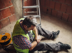 hurt construction worker sitting on ground