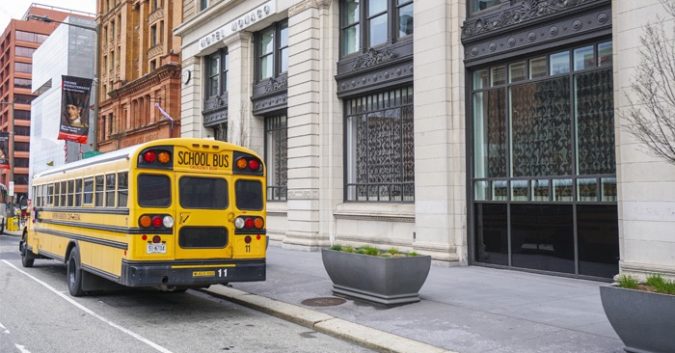 landscape shot of city buildings and a yellow school bus