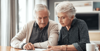 An older couple looks over documents at their table