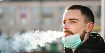 young man with respiratory mask smoking