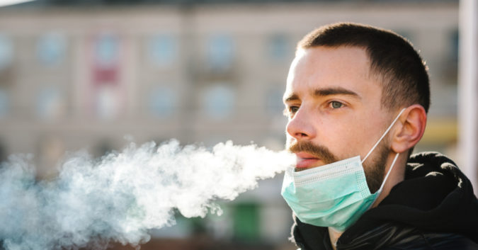 young man with respiratory mask smoking