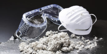 asbestos dust next to respirator and goggles