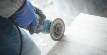 Quartz countertop worker cutting stone