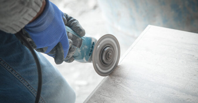 Quartz countertop worker cutting stone