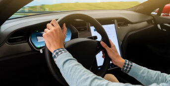 Person holds Tesla steering wheel