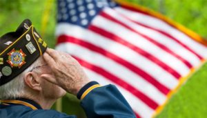 A veteran salutes an American flag