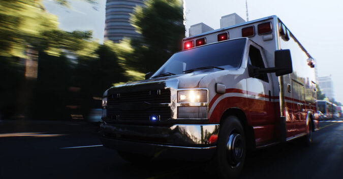 Ambulance driving down a city street with emergency lights flashing