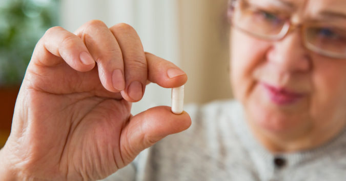 a woman holds a pill