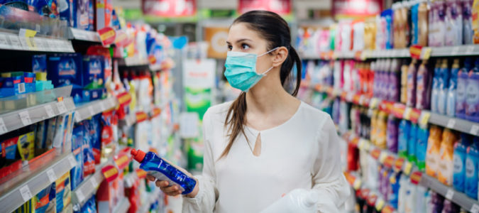 woman wearing a medical face mask walking through a store