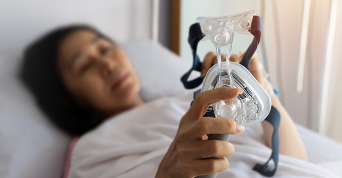 Woman holds CPAP mask